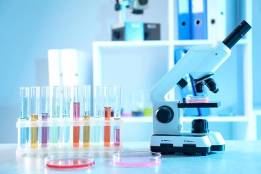 Laboratuvarda farklı numuneler, test tüpleri ve mikroskop bulunan petri kapları. Çözüm kimyası