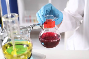 Laboratuvarda farklı örneklerle çalışan bir bilim adamı. Çözüm kimyası