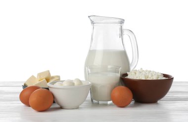 Farklı süt ürünleri ve yumurtalar beyaz arka plana karşı ahşap masa üzerinde