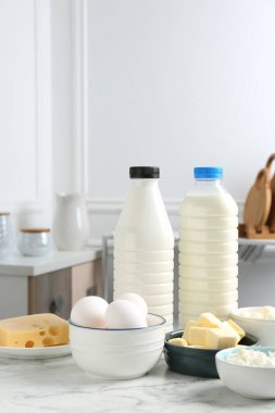 Beyaz mermer masa üzerinde farklı süt ürünleri ve yumurtalar.