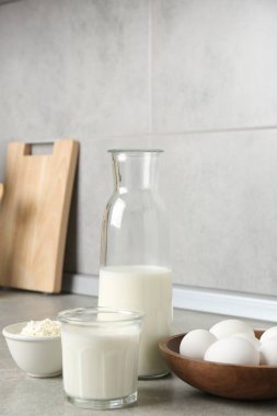 Mutfaktaki gri desenli masada farklı süt ürünleri ve yumurtalar.