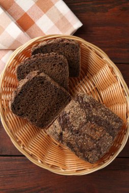 Hasır sepetin içinde taze çavdar ekmeği, ahşap masanın üstünde.