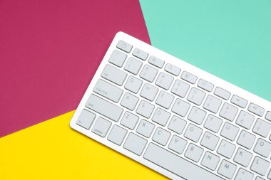 Renkli arka planda modern beyaz kablosuz klavye, üst görünüm. Metin için boşluk