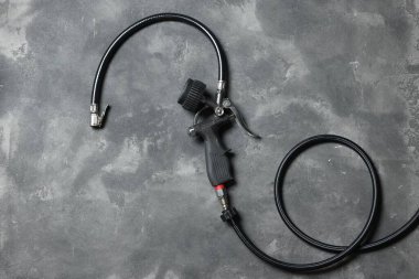 Gri arka planda göstergesi olan bir lastik enflasyon silahı.