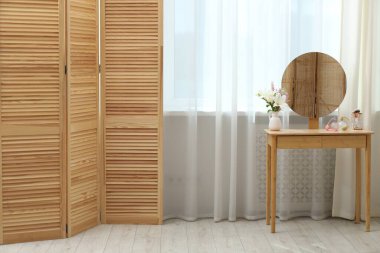 Pencerenin yanında şık mobilyalar ve oturma odasında perdeler. İç tasarım