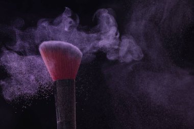 Siyah arka planda mor göz farlı makyaj fırçası, yakın plan