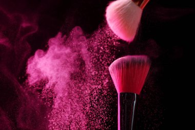 Siyah arka planda pembe göz farlı makyaj fırçaları, yakın plan. Metin için boşluk