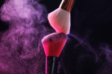 Siyah arkaplanda renk farlı makyaj fırçaları, yakın plan
