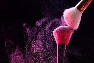 Siyah arka planda pembe göz farlı makyaj fırçaları, yakın plan. Metin için boşluk