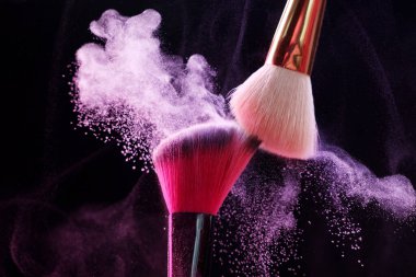 Siyah arkaplanda renkli göz gölgeli makyaj fırçaları, yakın plan