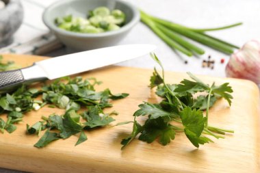 Farklı taze otlar, baharatlar ve bıçaklar masada, yakın plan.