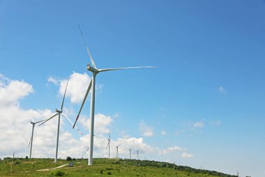 Güneşli bir günde modern rüzgar türbinleri tarlada. Metin için boşluk