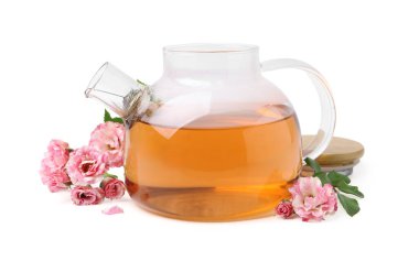 Cam çaydanlıkta leziz bir gül çayı, beyazın üzerinde izole edilmiş çiçekler ve yapraklar.