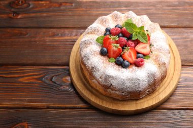 Tahta masada pudra şekeri ve böğürtlenli Lezzetli kek, mesaj için yer var.
