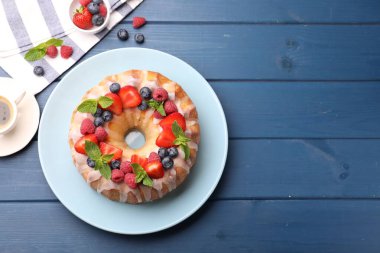 Böğürtlenli enfes kek, mavi ahşap masa üzerinde şeker ve nane, düz yatak. Metin için boşluk