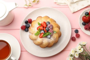 Pudra şekeri, böğürtlen ve nane şekerli nefis kek pembe ahşap masa, düz yatıyordu