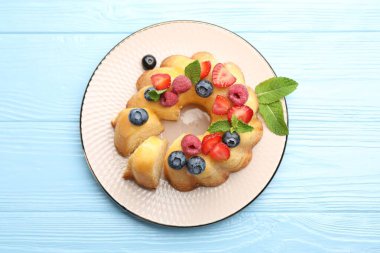 Böğürtlenli kek ve açık mavi ahşap masada nane şekeri.