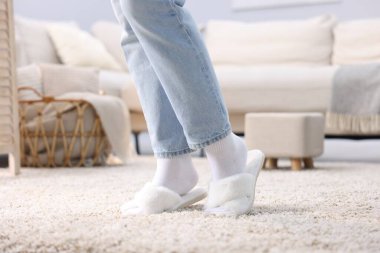 Evdeki yumuşak halıda beyaz terlikli kadın, yakın plan.