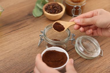 Doğal temizlik yapıyorum. Ahşap masada kahvesini kavanoza koyan kadın, yakın plan.