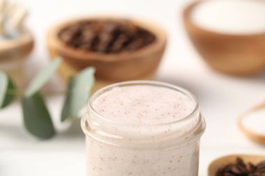 Bulanık arka planda cam kavanozda doğal vücut fırçası, yakın plan.