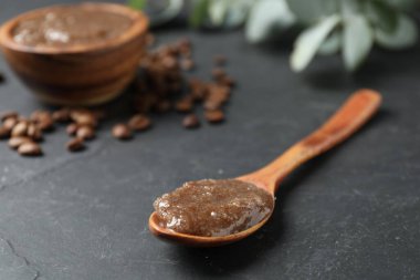 Siyah masada doğal vücut fırçası ve kahve çekirdeği, yakın plan.