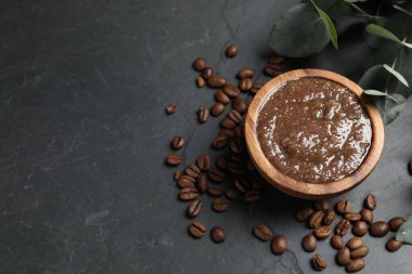 Doğal vücut fırçası, kahve çekirdekleri ve okaliptüs yaprakları siyah masada, düz yerde. Metin için boşluk