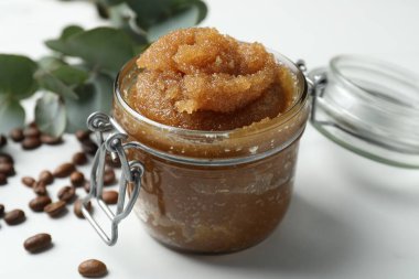 Doğal vücut fırçası, kahve çekirdekleri ve okaliptüs yaprakları beyaz masada, yakın plan.
