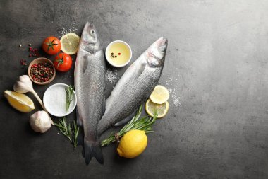 Gri masadaki baharatlı taze çiğ deniz kabuğu balığı, yazı için düzlük ve boşluk. Deniz ürünleri lezzetleri.