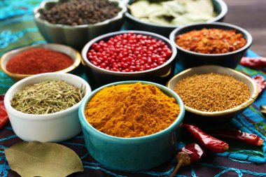 Mavi masa örtüsünde farklı aromatik baharatlar, yakın plan.