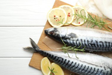 Deniz ürünleri lezzetleri. Taze çiğ uskumrular ve baharatlar beyaz ahşap masada, düz yerde. Metin için boşluk