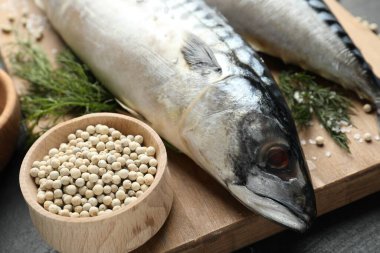 Masada taze çiğ uskumrular ve baharatlar, yakın plan. Deniz ürünleri lezzetleri.