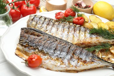 Baharatlı, domatesli ve patatesli kızarmış uskumrular, yakın plan. Ev yapımı deniz ürünleri yemeği.