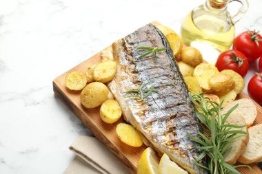 Beyaz mermer masanın üstünde baharat ve sebzeli kızarmış uskumru. Ev yapımı deniz ürünleri yemeği.