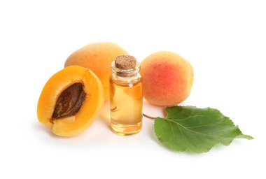 Bir şişe gerekli yağ, taze kayısılar ve beyaz üzerine izole edilmiş yeşil yaprak.