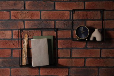 Kare şekilli raflar, kitaplar ve tuğla duvarda ev dekorasyonu.