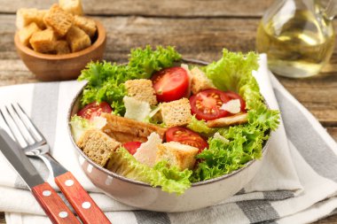 Ahşap masada sunulan kıtır ekmekli lezzetli salata, yakın plan.