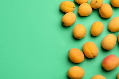 Yeşil arka planda bir sürü taze kayısı, düzlük. Metin için boşluk