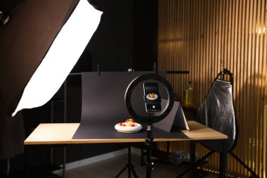 Stüdyoda akıllı telefonla lezzetli makarna çekmek, ekrana odaklanmak. Profesyonel yemek fotoğrafçılığı.