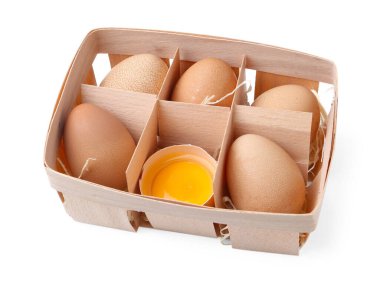 Ahşap tepside bütün ve kırılmış tavuk yumurtaları beyaza izole edilmiş.