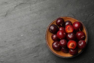 Koyu dokulu masada kasede olgun kiraz erikleri, üst manzara. Metin için boşluk