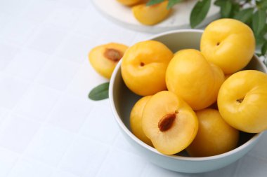 Beyaz fayanslı masada olgun sarı kiraz erikleri, yakın plan. Metin için boşluk