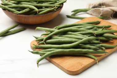 Beyaz masada taze bezelye kabukları, yakın plan.