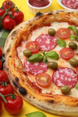 Salamlı, zeytinli, domatesli ve fesleğenli lezzetli pizza.