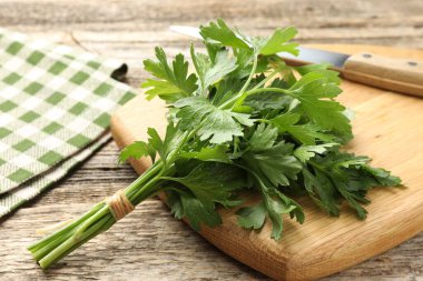 Bir demet taze maydanoz ve bıçak ahşap masada, yakın plan.