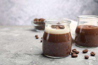 Gri desenli masada nefis panna cotta ve kahve çekirdekleri, yakın plan. Metin için boşluk