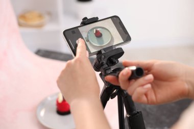 Stüdyoda lezzetli tatlıların fotoğrafını çeken bir kadın, seçici bir odak noktası. Profesyonel yemek fotoğrafçılığı.