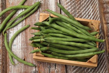 Taze bezelye kabukları ve sandıklar renkli ahşap masa, düz uzanma