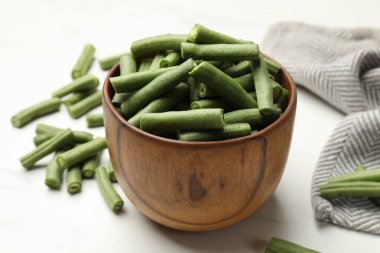 Beyaz masada taze bezelye kabukları, yakın plan.