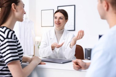 Tüp bebek (tüp bebek). Üreme kliniğinde doktorla randevusu olan çift, seçici odaklanma