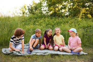 Çocuklar yaz günü doğada vakit geçirirler.